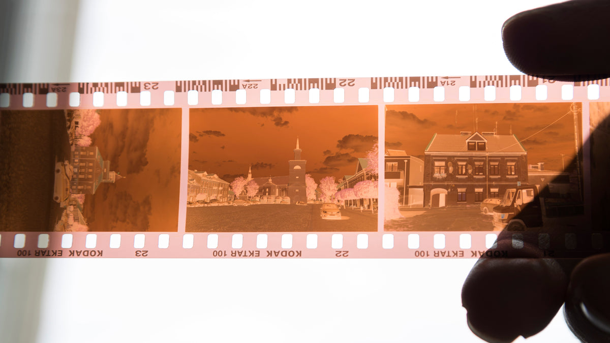 Orange color negative film strip held against daylight