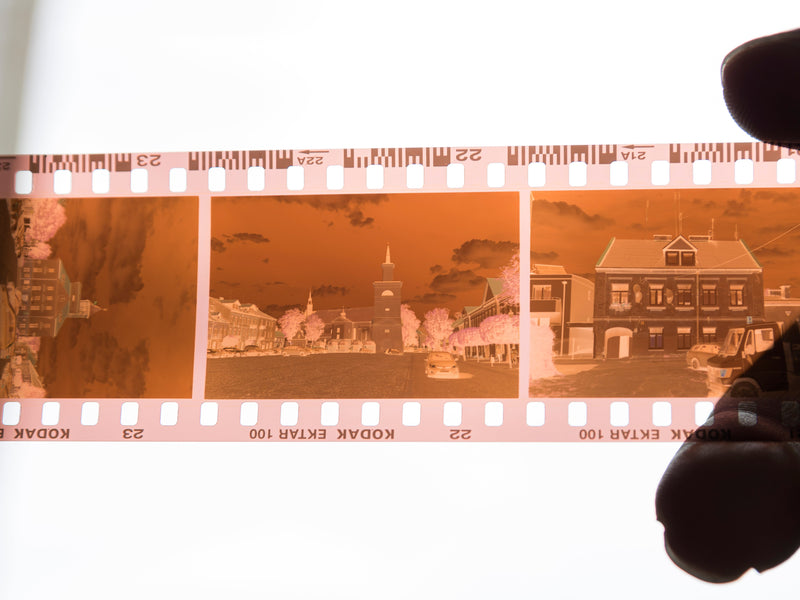 Orange color negative film strip held against daylight