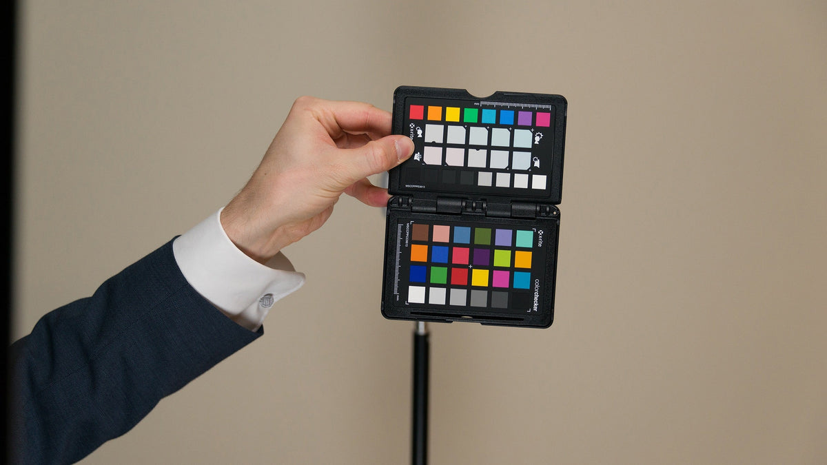 Photographer holding a ColorChecker Passport for a neutral color reference