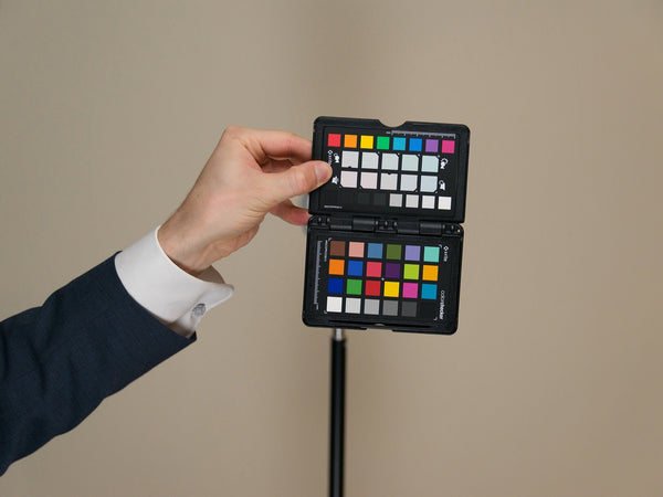 Photographer holding a ColorChecker Passport for a neutral color reference