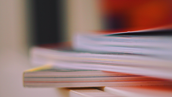 Shallow-focus stack of printed books for a Lightroom learning guide